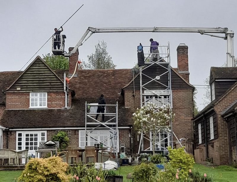The Roof Moss Cleaners using cherry picker and scaffolding to clean roof safely and professionally in Woking, Surrey